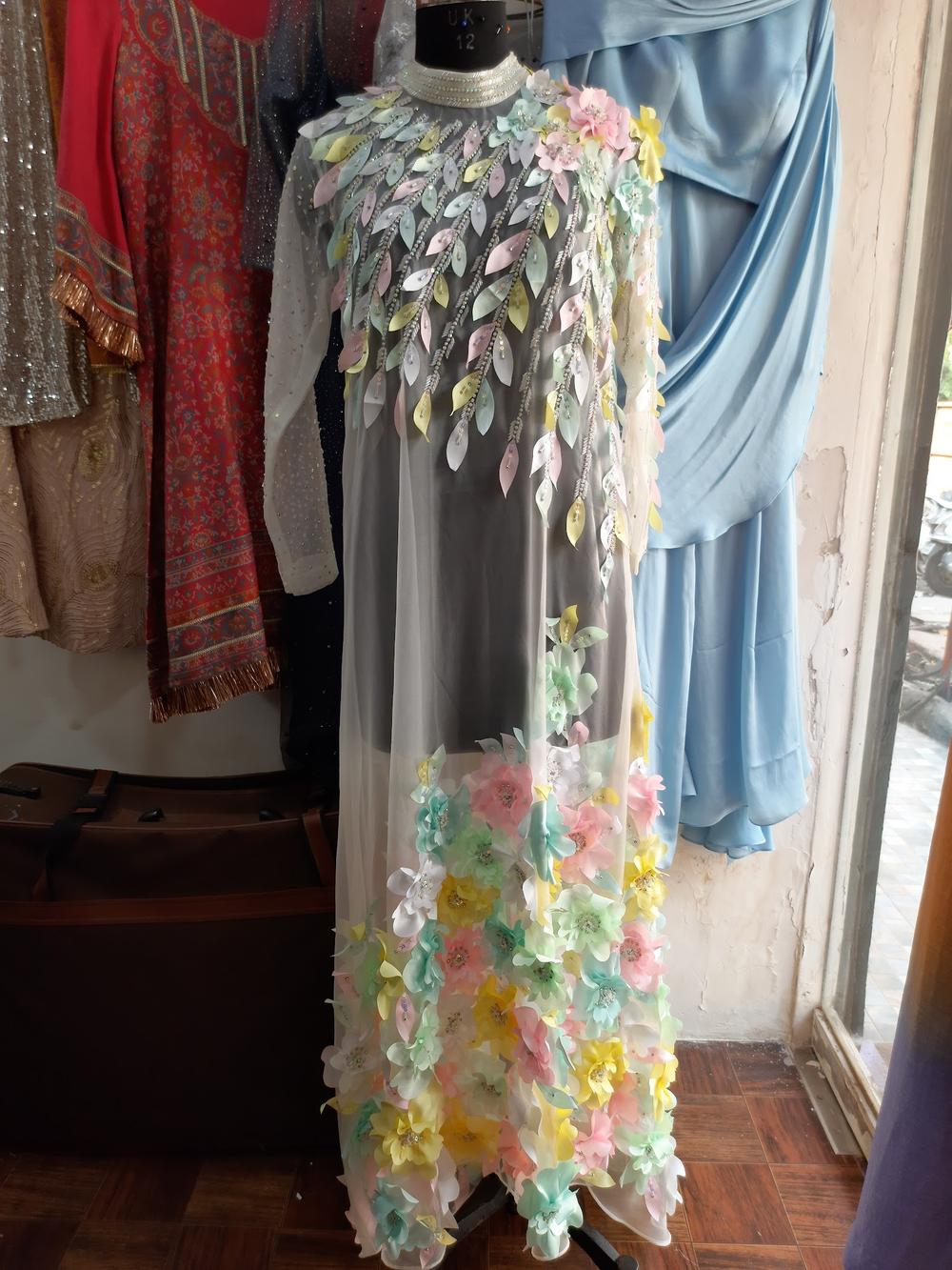 A pastel floral-appliqué gown on a mannequin